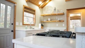 A kitchen with a central island, wooden beams, and built-in shelves. - Eremos – A Peaceful Browside Escape with Unforgettable Views (Mentone)