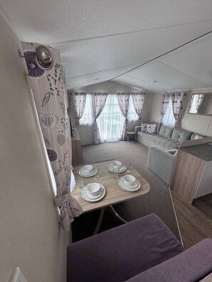 Un espacio habitable compacto con comedor, kitchenette y zona de estar.