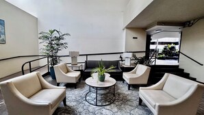 Eine Lobby mit zwei Sofas, einem Couchtisch und einer Topfpflanze.