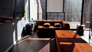 Ein modernes Interieur mit einer Couch, einem kleinen Tisch und einem großen Fenster.
