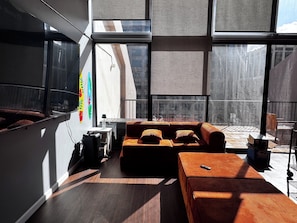 A modern interior with a sofa, a small table, and a large window.