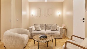 Una sala de estar moderna con sofá, sillones, una mesita de centro e iluminación empotrada.