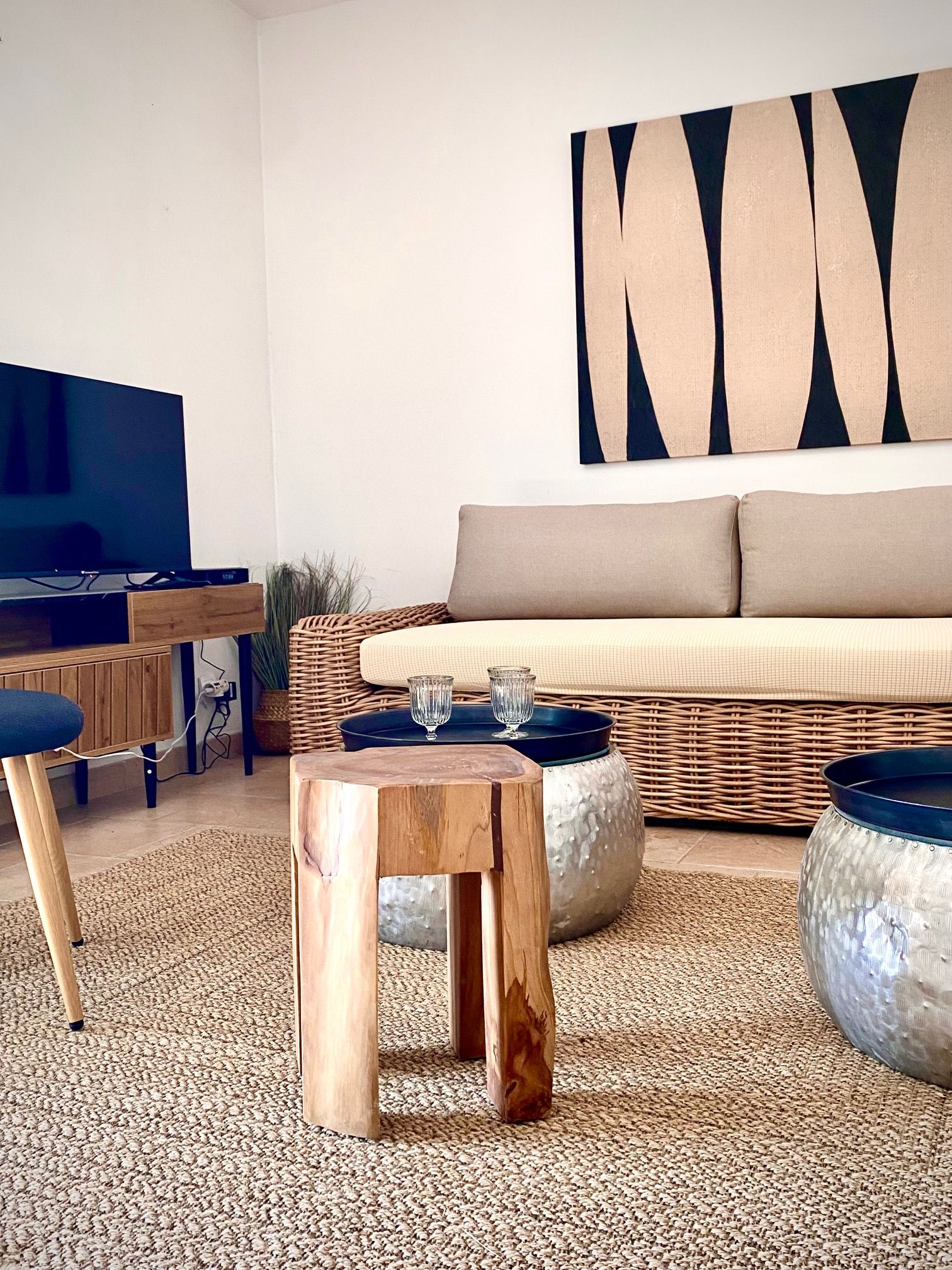 A modern living room with a television, sofa, coffee table, and decorative items.