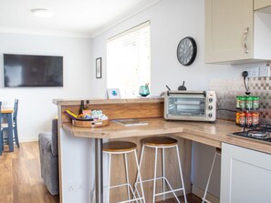 Een keuken met een ingebouwde toaster, een klok en een raam.