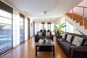 A spacious living room with a sofa set, a coffee table, and a staircase. - Villa del Sur - Luxury with heated pool and BBQ (Mogán)