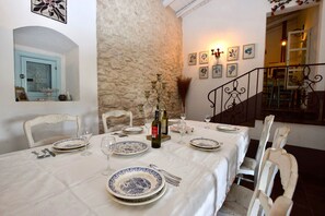 Ein Essbereich mit Steinwand, Treppe und Blick ins Innere.
