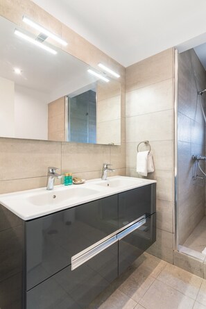 A modern bathroom with two sinks, a large mirror, and a glass shower enclosure. - Villa Chil - Luxury with heated pool and BBQ (Mogán)