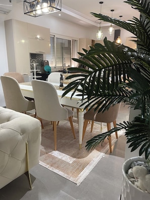 A modern dining area with a white table, beige chairs, and a decorative rug. - Yasmine Hammamet near Carthage land a villa with swimming pool  (Yasmine Hammamet)
