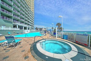 A pool area with lounge chairs, a hot tub, and a sign indicating no diving. - FREE Golf! Boardwalk 2006 King Master, Walk in Shower, Hot Tubs, Heated Pool! (Panama City Beach)