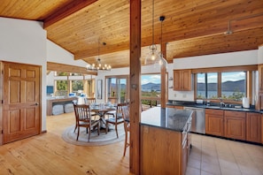 Una cocina amplia con armarios de madera, una isla grande y un comedor con una mesa redonda y sillas.