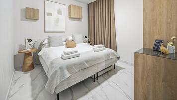 Ein modernes Schlafzimmer mit einem Bett, einem Nachttisch und einem Holzkasten.