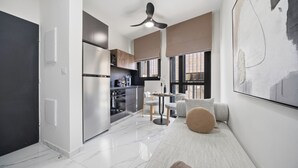 Une cuisine moderne équipée d’un réfrigérateur, d’une cuisinière et d’un coin repas avec des chaises et une table.