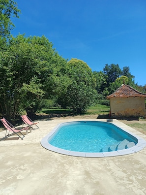 A swimming pool with lounge chairs, surrounded by trees and a small building. - Gîte Le Bergerayre 10 people Swimming pool/Campagne 4-star accommodation (Saint-Griède)
