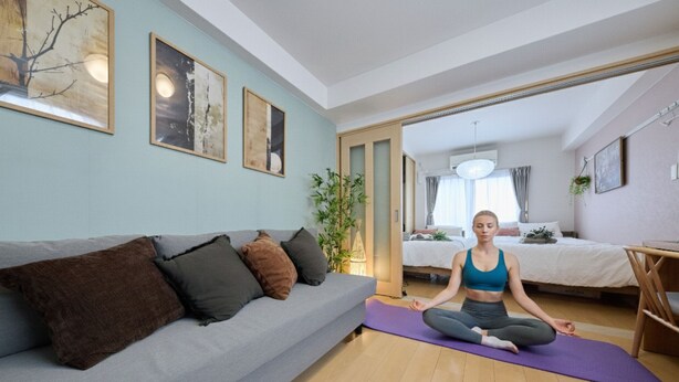 Ein Zimmer mit einer Couch, einer Yogamatte und einem Bett.