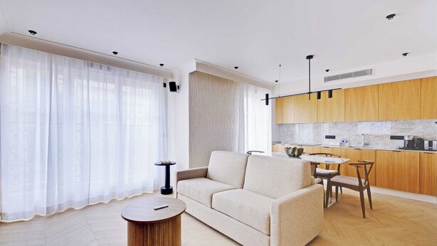 A modern living room with a sofa, round coffee table, and a dining area with chairs. - Comftable Apartment a/c 1br/4p - Saint-mande (Saint-Mandé)