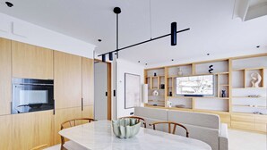 A modern kitchen with wooden cabinets, a marble countertop, and a dining area with a table and chairs. - Comftable Apartment a/c 1br/4p - Saint-mande (Saint-Mandé)