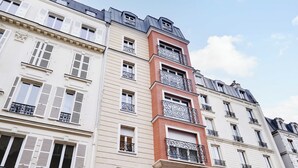 A multi-story building with white and red facades, multiple balconies, and a classic architectural style. - Comftable Apartment a/c 1br/4p - Saint-mande (Saint-Mandé)