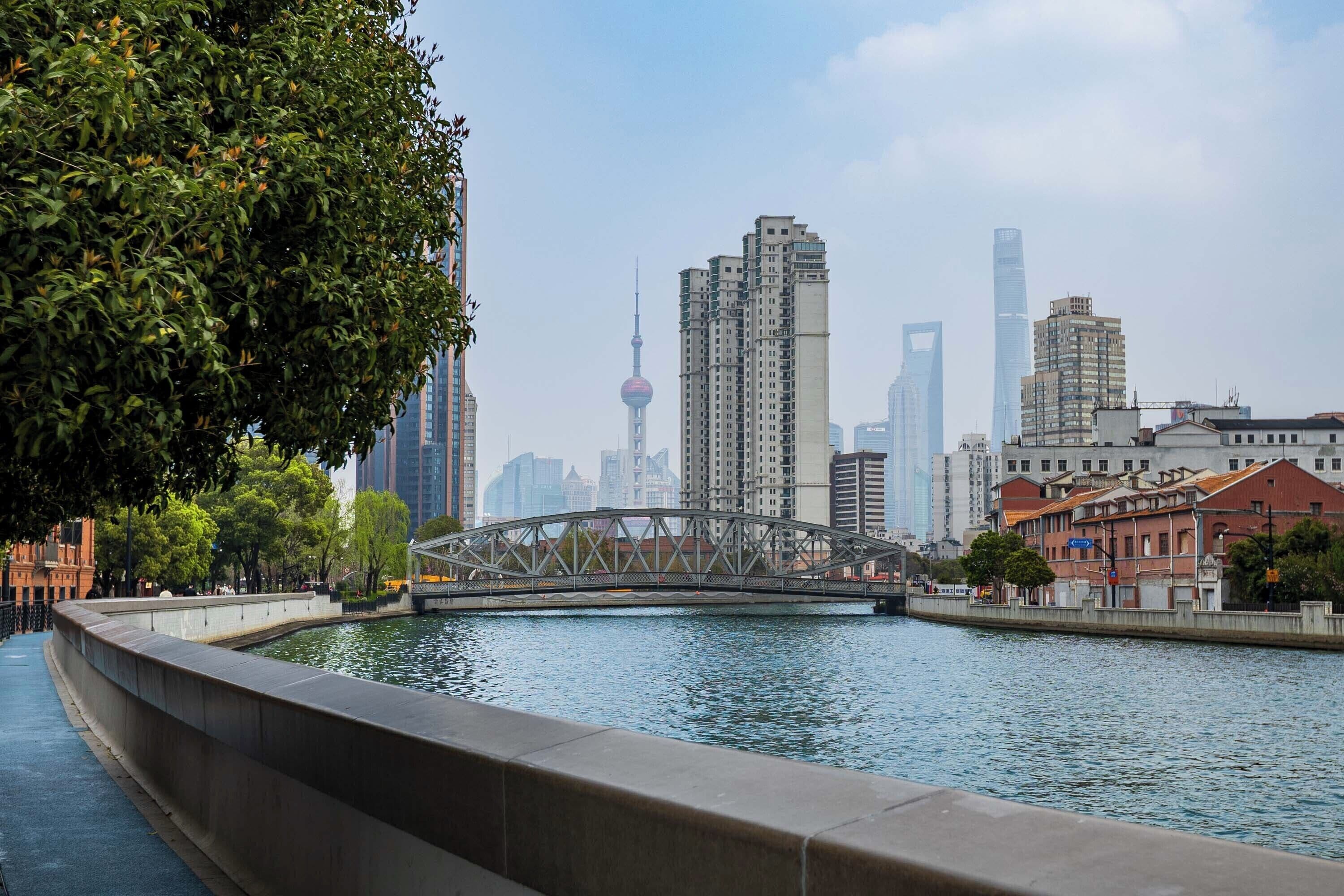 A river with a bridge, city skyline, and buildings.