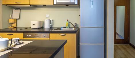 A compact kitchen with a microwave, a refrigerator, a coffee maker, and a dishwasher.