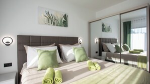 Habitación de hotel con cama, almohadas, un espejo y una obra de arte en la pared.