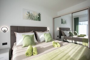 Ein Hotelzimmer mit Bett, Kissen, einem Spiegel und einem Wandbild.