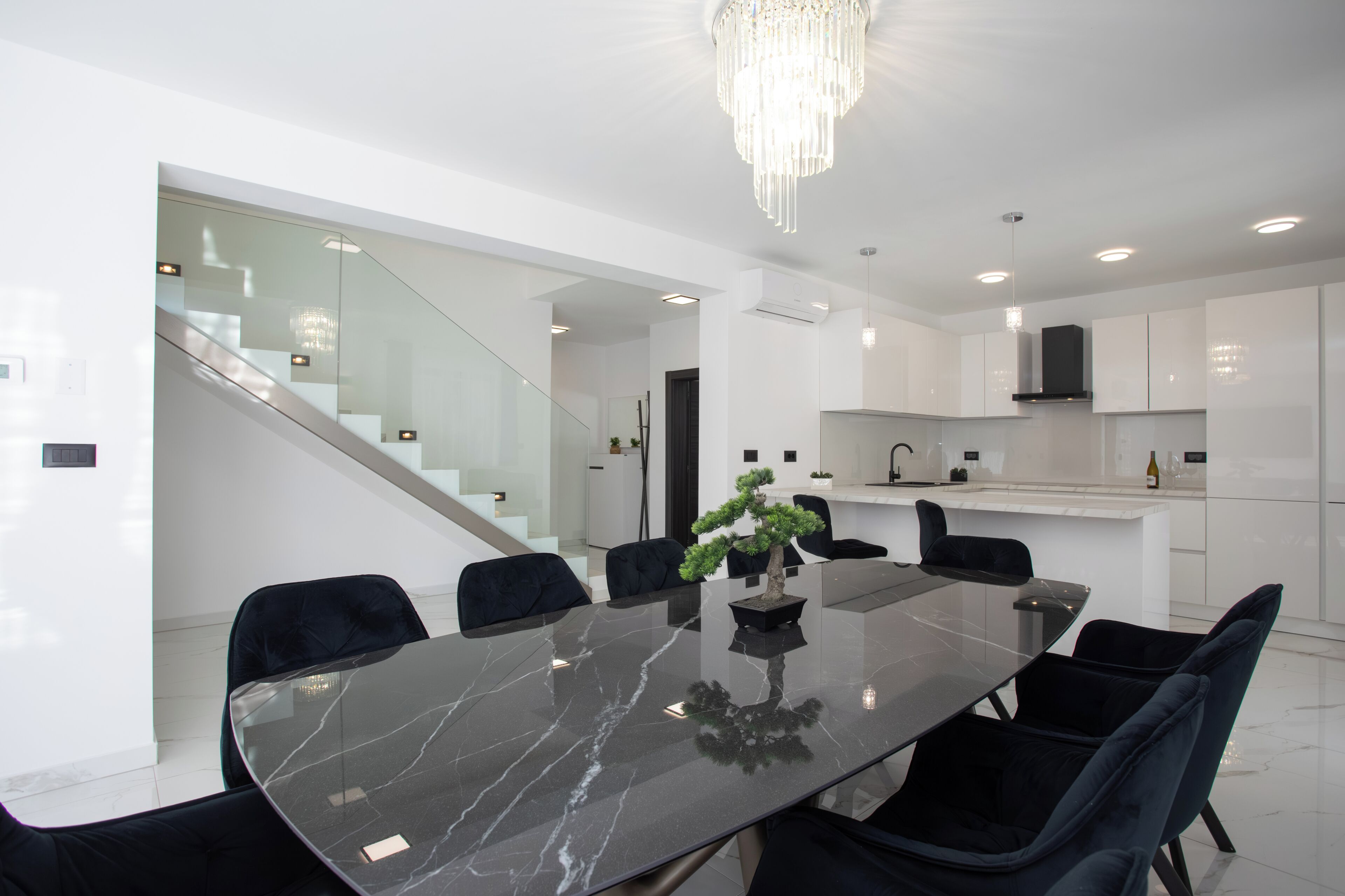 A modern kitchen with white cabinets, a black countertop, and a built-in stove.
