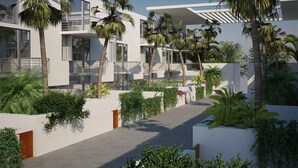 A modern building with balconies, palm trees, and a pathway. - Luxury Tennis Retreat Near Siesta Key, Bath and Racquet Club. Sleeps 4. (Sarasota)