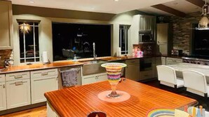 Una cocina moderna con encimeras de madera, una isla central y un jarrón de colores.
