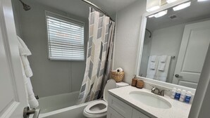 A bathroom with a bathtub, toilet, sink, and a large mirror. - Cozy 1-bedroom apartment in beautiful Virginia Beach with AC (Virginia Beach)