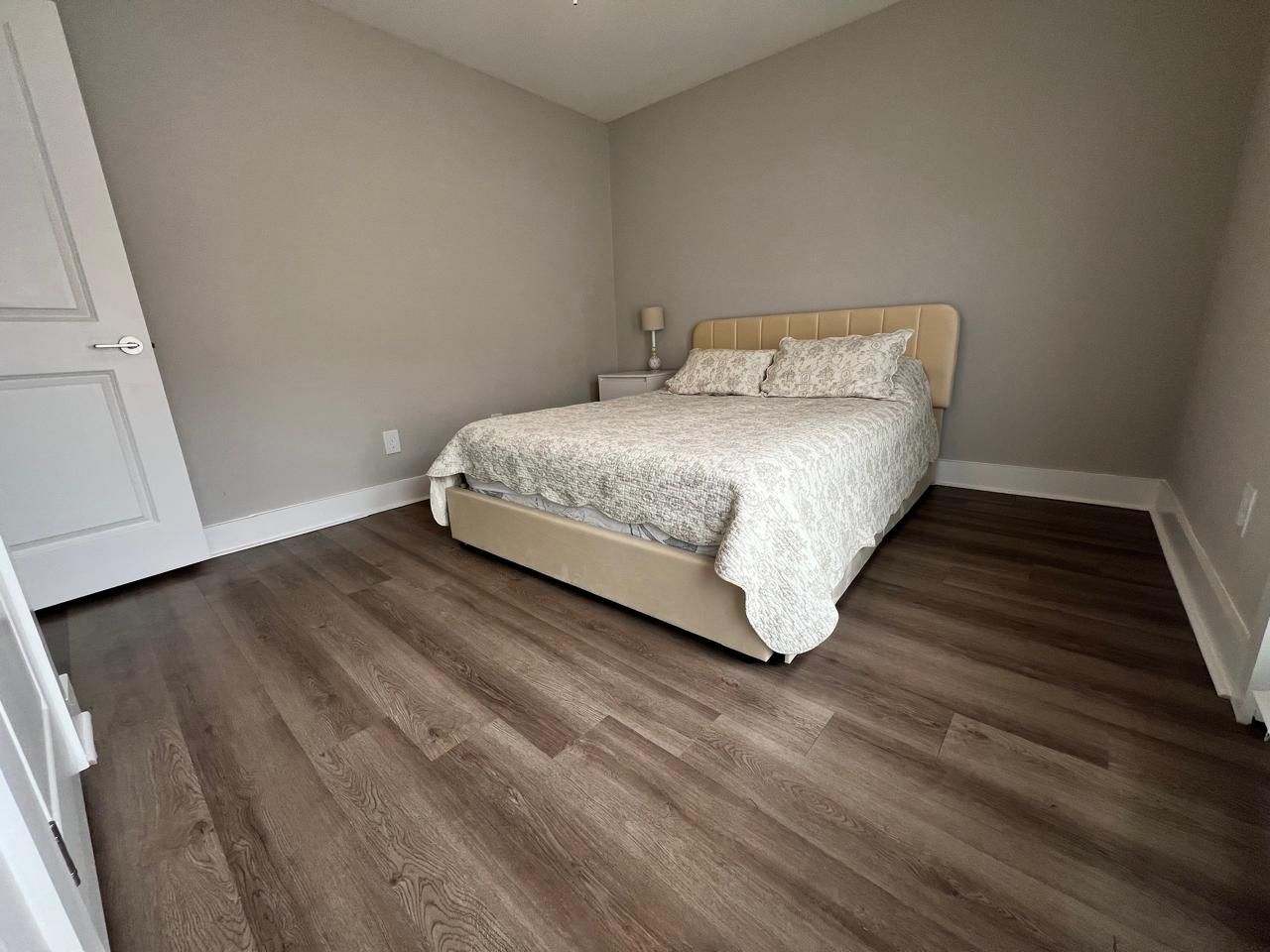 Una camera da letto con un letto, un comodino e una porta.