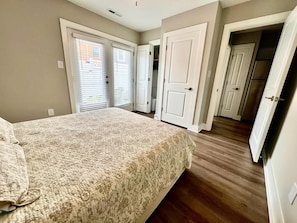 Un dormitorio con cama, armario y puerta que da a un pasillo.
