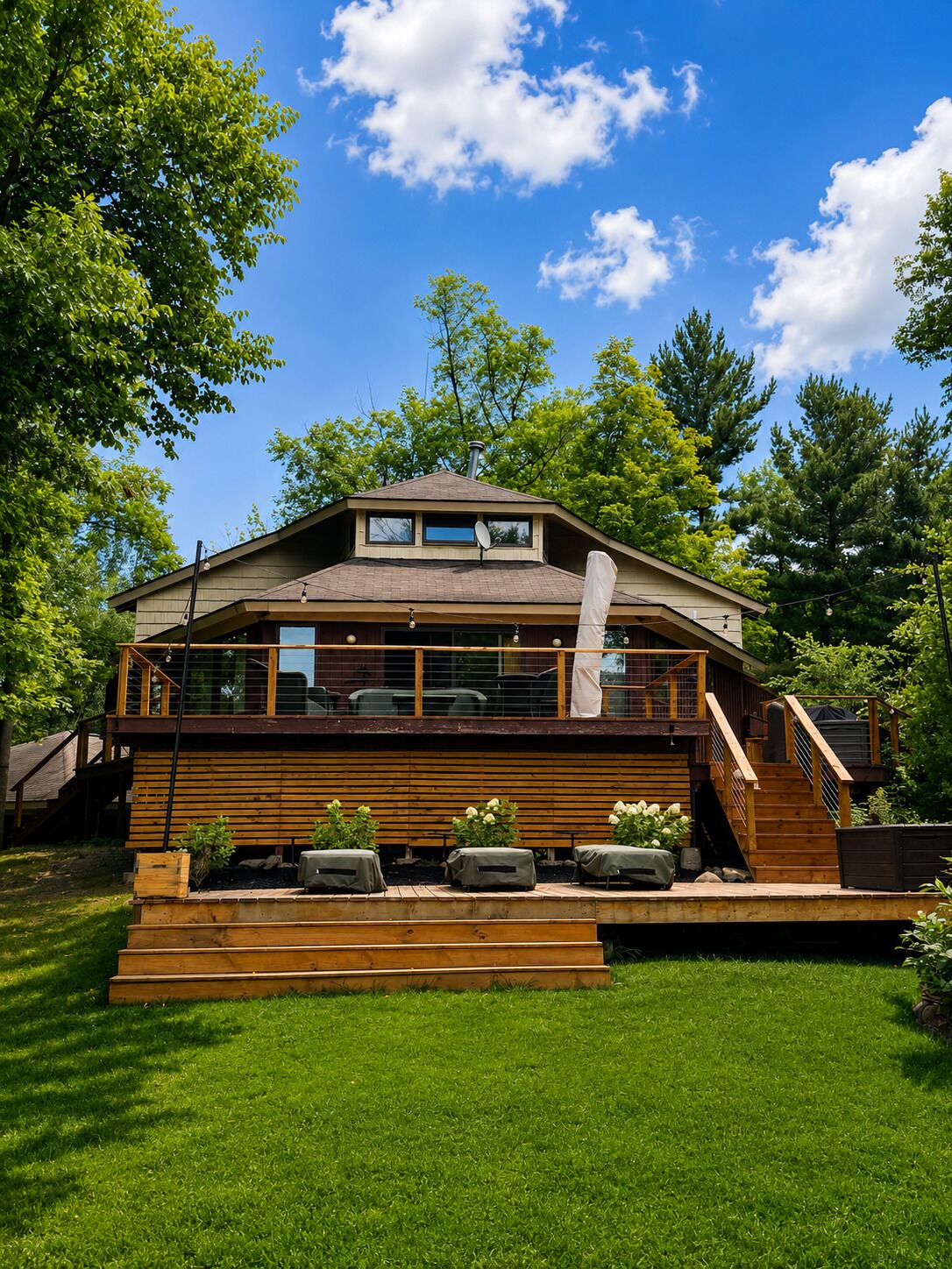 A two-story house with a deck, a satellite dish, and a chimney.