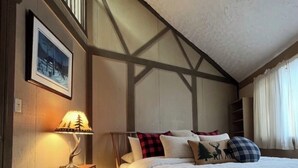 A bedroom with a bed, a nightstand, a lamp, a picture on the wall, and a window with curtains. - Hexagon Hideaway on Balsam Lake • Private Dock • Kayaks • Sunset Views (Balsam Lake)