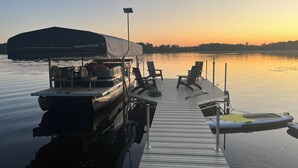 A dock with a covered boat named 'Porta Dock,' two lounge chairs, and a small inflatable boat. - Hexagon Hideaway on Balsam Lake • Private Dock • Kayaks • Sunset Views (Balsam Lake)
