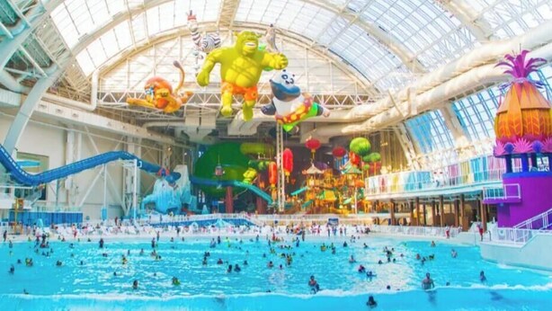 An indoor water park with multiple pools, slides, and various water attractions. - DivineComfort (Newark)