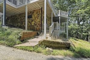 A two-story building with a stone facade, wooden steps leading to a porch, and a small wooden deck. - Vista Ridge at Alpine 4bdr (Jasper)