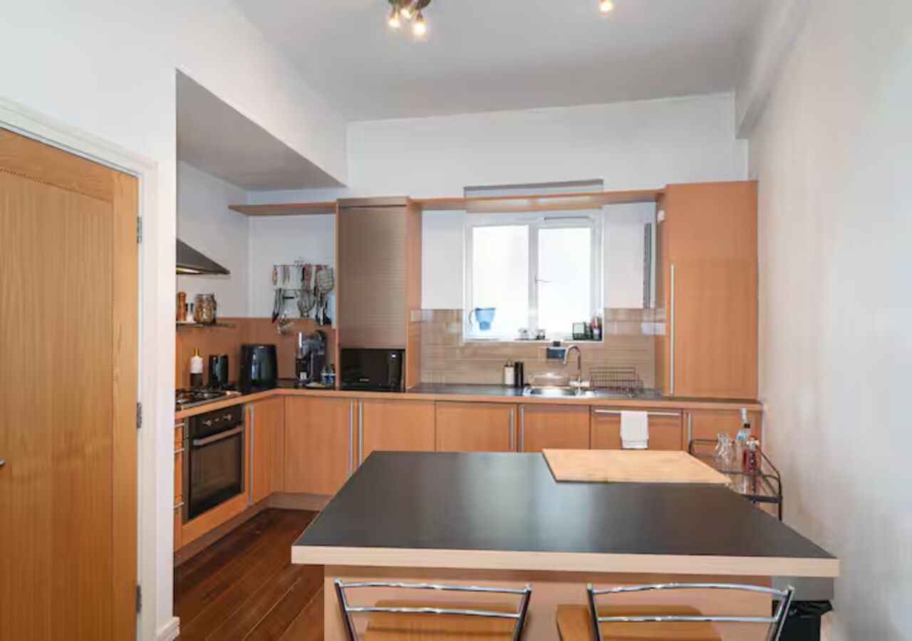 Una cucina moderna con mobili in legno, un'isola centrale e un forno integrato.