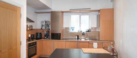 Una cucina moderna con mobili in legno, un'isola centrale e un forno integrato.