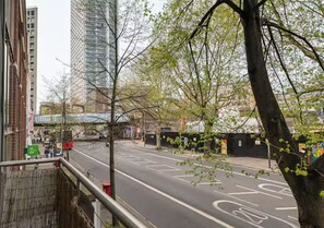 A city street with a bicycle lane, buildings, and a tree. - Modern 1 Bedroom Flat in Central London - Pass the Keys (London)