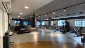 Et fitnesscenter med løbebånd, boksebold og styrketræningsudstyr.