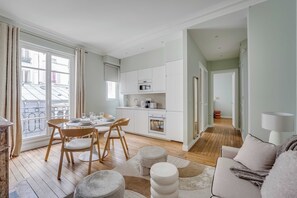 A modern apartment with a dining area, kitchen, and living room. - Design Apartment 1br/4p - Monceau (Paris)
