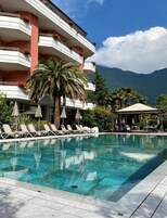 Una piscina al aire libre de temporada, sombrillas