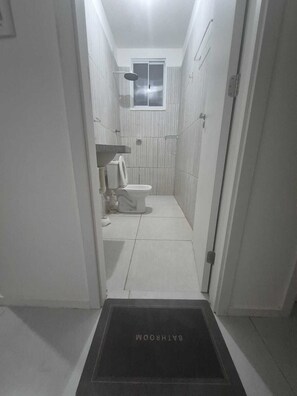 Chuveiro, secador de cabelo, toalhas de banho, papel higiênico