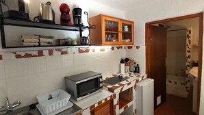A kitchen with a microwave, a coffee maker, a kettle, and a cabinet with glass doors. - Casa Lara Hermigua - Studio ESTAMBUL with terrace - Ideal for families (Hermigua)