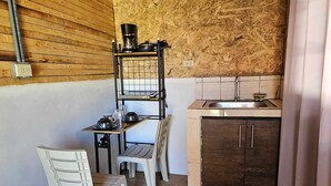 A compact kitchen with a sink, a small table, and two chairs.