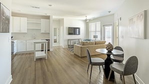 A modern apartment with a kitchen, dining area, and living room. - Landing Apartments Huntsville near Lake Forest (Huntsville)