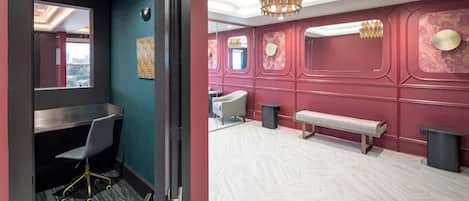 Um saguão moderno de hotel com balcão de recepção, área de estar e painéis decorativos na parede.