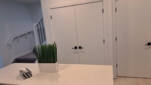 Een moderne keuken met witte kasten, een aanrecht en een potplant.
