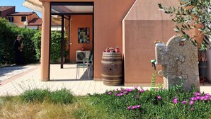 A modern building with a sloped roof, a stone barrel, and a stone wall with a water feature. - La Serenissima: beach, bicycle and Venice !!! (Punta Sabbioni)