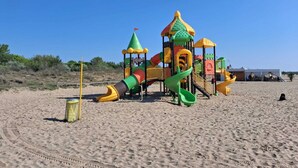 A beach playground with a castle-like structure, slides, and a climbing area. - La Serenissima: beach, bicycle and Venice !!! (Punta Sabbioni)